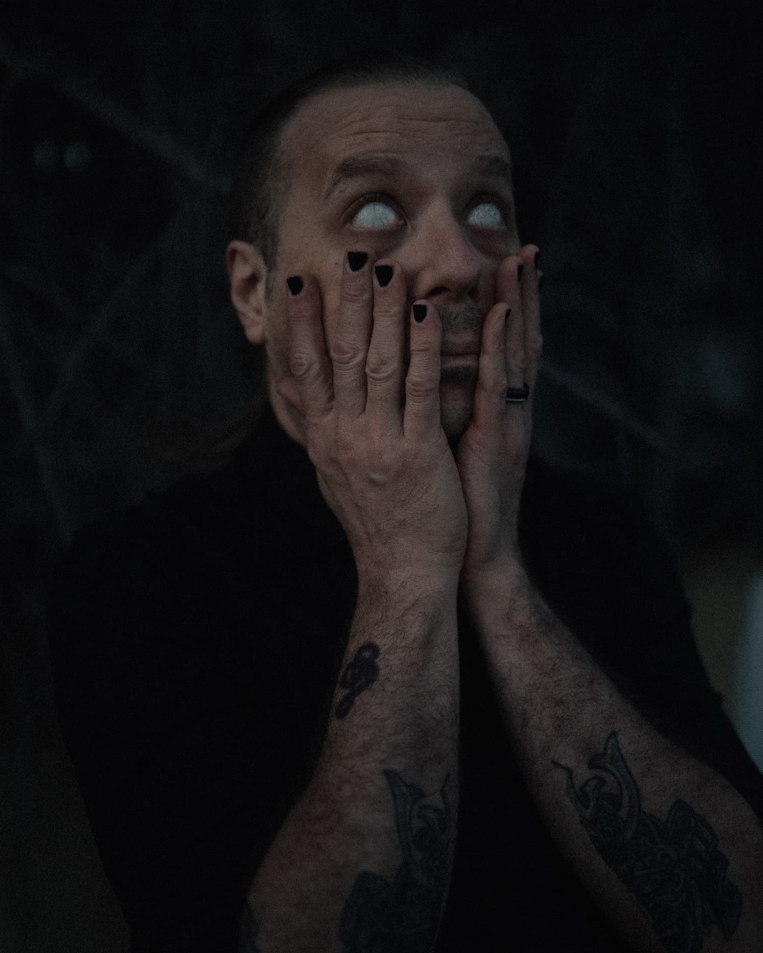 Portrait of Voidova with pale eyes, hands framing the face